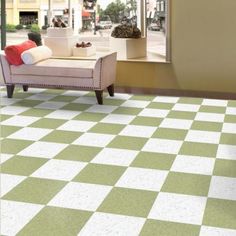 a living room with checkered tile flooring and furniture in front of a window