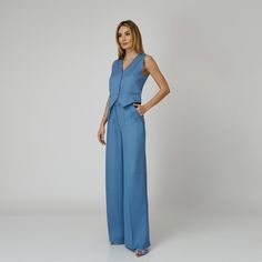 Introducing our Skye Silk Crepe Pants, a statement of luxurious comfort and timeless style. Tailored from  blue silk crepe with a wide-leg cut, they feature expertly placed darts that contour the waist and flatter the silhouette. The pressed crease detail offers a touch of refinement, elevating the overall look with understated polish. A concealed zipper and hook fastening in the front ensures a seamless finish, while the inclusion of pockets adds a practical yet chic element to the ensemble.  M Chic Blue Silk Pants, Blue Silk Wide-leg Bottoms, Blue Silk Wide Leg Bottoms, Blue Silk Pants For Work, Modern Wide Leg Pants For Summer Formal Events, Modern Wide Leg Pants For Summer Formal Occasions, Modern Formal Wide Leg Pants For Summer, Elegant Wide Leg Silk Pantsuit, Modern Wide Leg Blue Pants