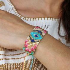 a woman wearing a colorful bracelet with beads