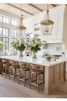 a large kitchen with an island and lots of stools in front of the counter