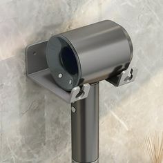 a silver toilet paper dispenser mounted to the side of a marble wall