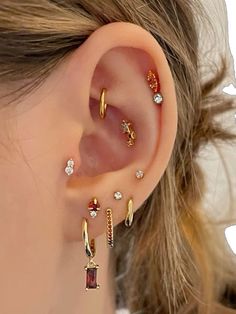 a woman wearing three different types of ear piercings on her left side, and one with