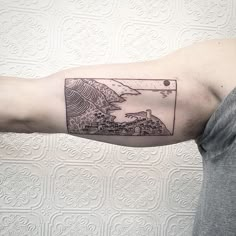 a man with a tattoo on his arm that has an image of the ocean in it