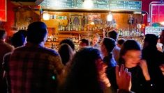 a group of people standing in front of a bar