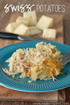 a blue plate topped with mashed potatoes on top of a wooden table next to a knife and fork