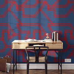 a desk and chair in front of a blue wall with red lines on it