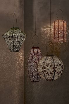 three hanging lanterns with intricate designs on them