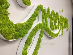 the letters are made out of moss and have been placed in different directions to create an interesting logo