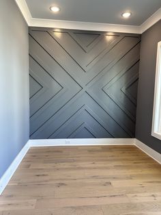 an empty room with wood floors and gray walls