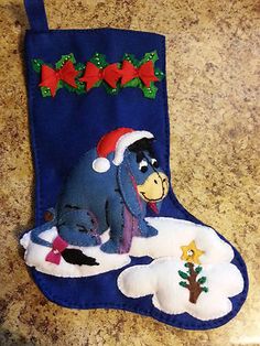 a blue christmas stocking with winnie the pooh sitting on it's side