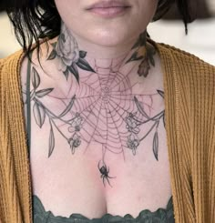 a woman with tattoos on her chest is looking at the camera