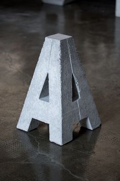 a concrete letter sitting on top of a floor