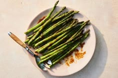 asparagus on a plate with a knife and seasoning sprinkles