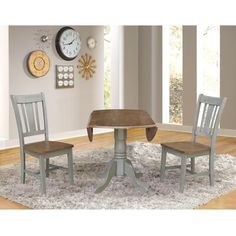 a dining room table with two chairs and a clock on the wall