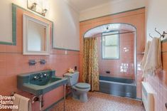 a bathroom with pink and blue tiles on the walls, sink, toilet and bathtub