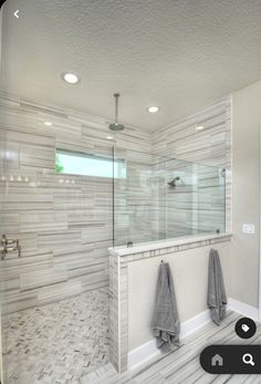 a bathroom with a walk in shower next to a bathtub and two towels hanging on the wall