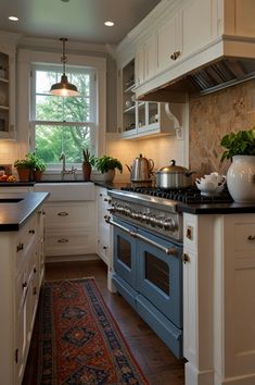 a kitchen with white cabinets and blue stove top oven