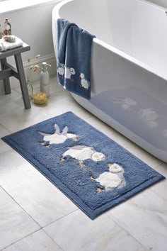 a bathroom rug with ducks on it in front of a bathtub and sink area