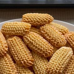 a white plate topped with crackers on top of a window sill next to a window