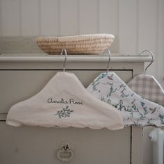 three towels hang from a clothes rack with a basket in the background