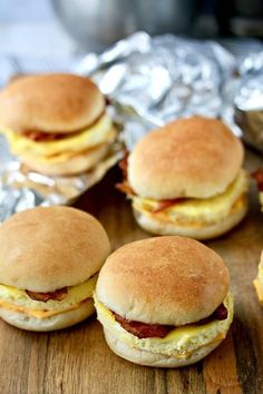 several breakfast sandwiches sitting on top of aluminum foil