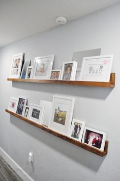 two wooden shelves filled with pictures on top of each other next to a white wall