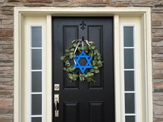 a door with a wreath and star of david hanging on it's front door