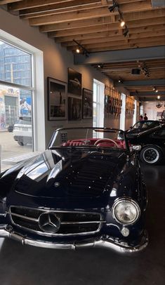 an old black car is parked in a showroom