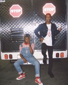 two people are sitting on the back of a bus in front of an advertisement for children's crossing