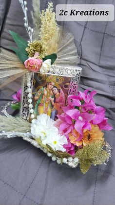 a bouquet of flowers sitting on top of a bed next to a card holder with an image