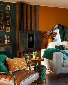 a living room with orange walls and green accents on the walls is furnished with furniture