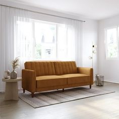 a living room with white curtains and a brown couch in the middle of the room