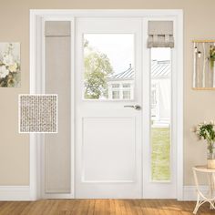 a white front door with two sidelights and matching shades on the window sill