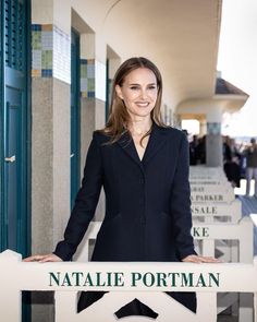 a woman standing in front of a sign that says natalie portman