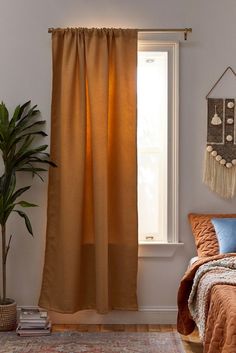 a bed sitting under a window next to a potted plant