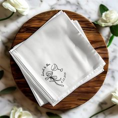 three white napkins sitting on top of a wooden plate