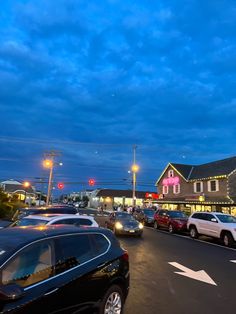 cars are driving down the street at dusk