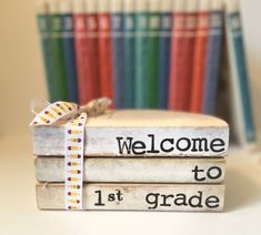 a stack of books with the words welcome to 1st grade written on them and a ribbon