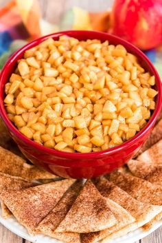 a red bowl filled with food sitting on top of a plate next to crackers