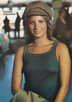 a woman wearing a hat standing in an airport