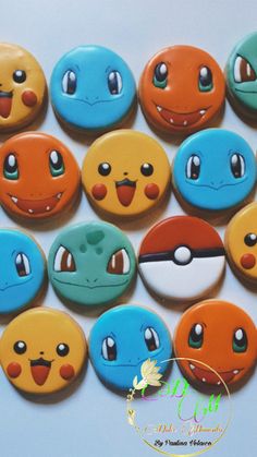 many different colored pokemon buttons on a white surface with one smiling and the other frowning