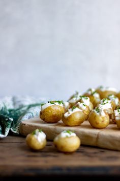 small potatoes on a wooden cutting board with green garnish