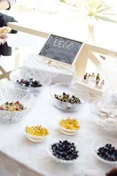 a table topped with lots of small bowls filled with different types of candy and candies