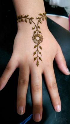 a woman's hand with a hendi on it and flowers painted on the wrist