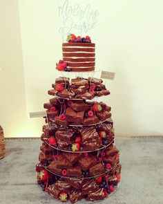 a large stack of chocolate cakes with strawberries on top