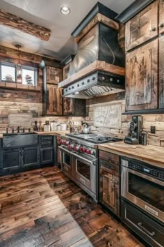 a kitchen with wooden floors and black cabinets, an oven, stove top and microwave