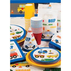 a table topped with plates and cups filled with construction themed paper napkins on top of a table