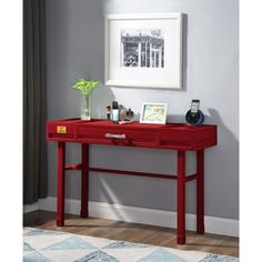 a red desk with two drawers and a phone on it