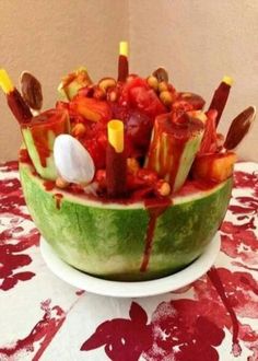 a watermelon bowl filled with candy and candies on top of a table