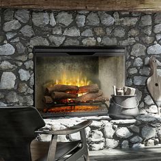 a stone fireplace with logs burning in it